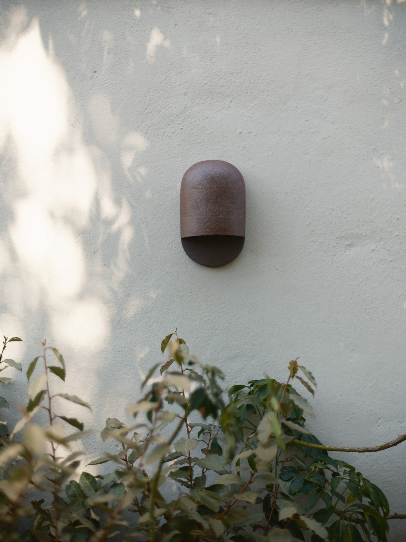 Ceramic sconce on a white stucco wall